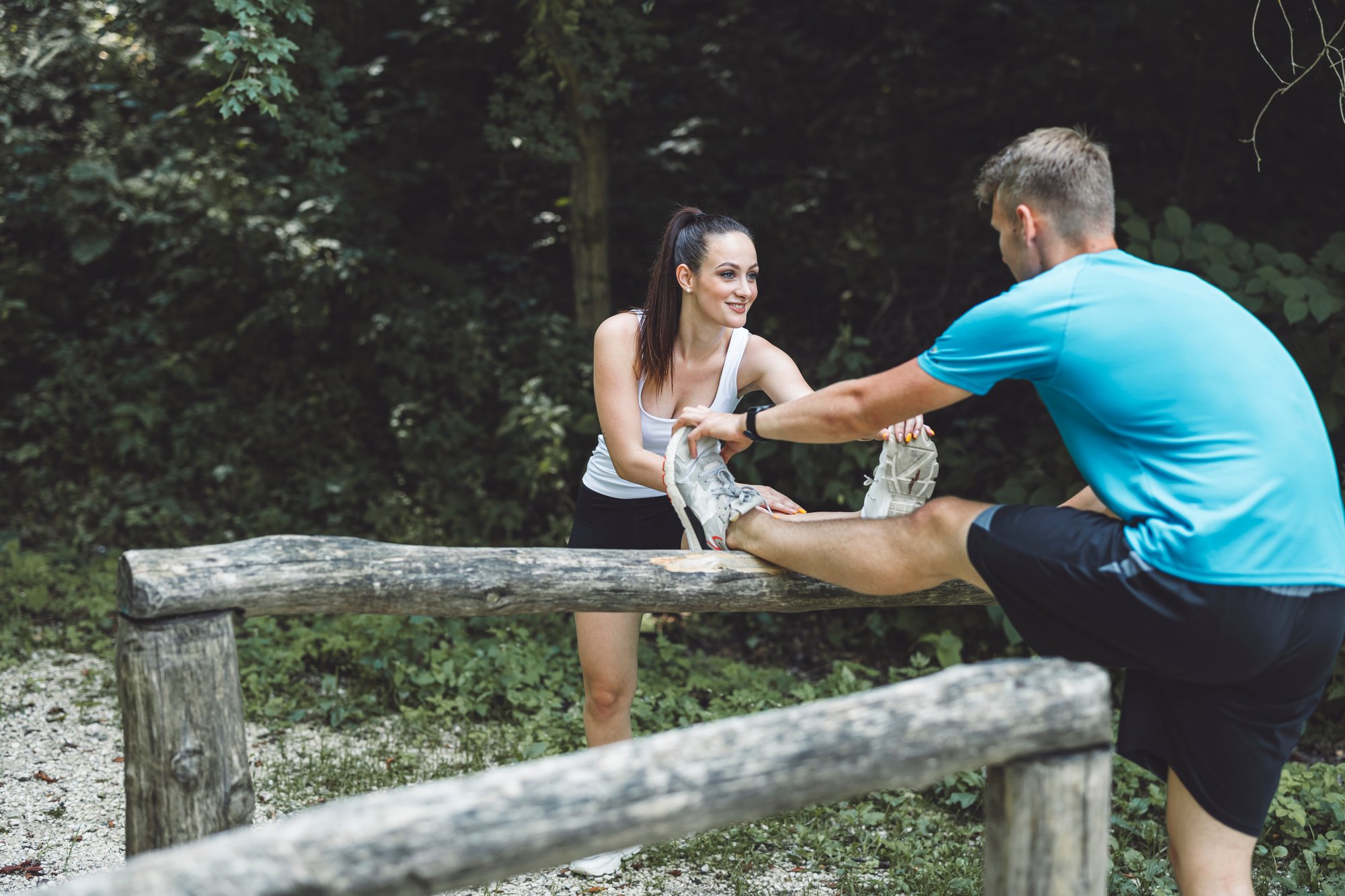 a-woman-assists-a-man-in-stretching-his-leg-on-a-w-2025-01-29-04-33-08-utc